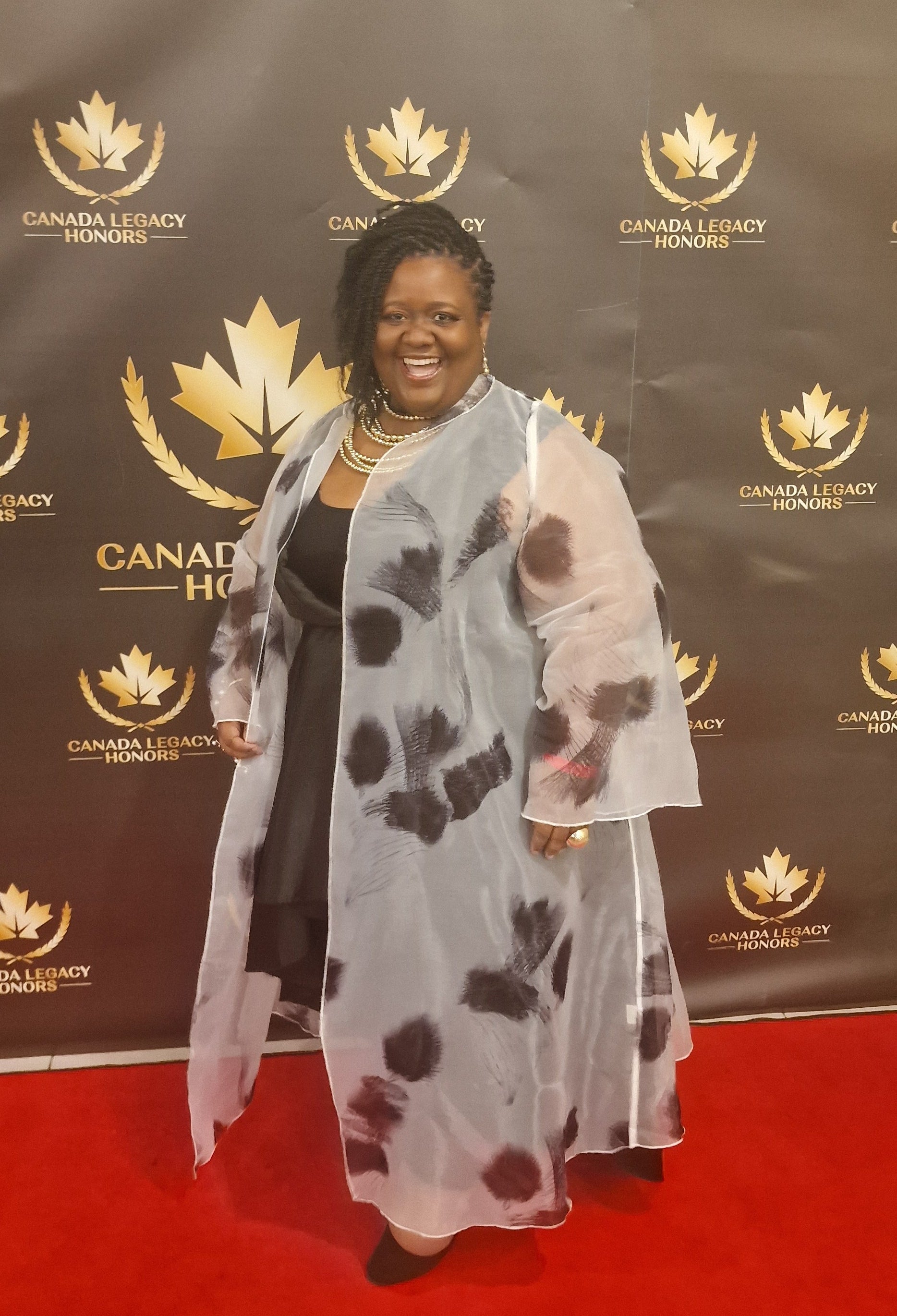 Cristal Legrand standing on a red carpet in front of a branded backdrop for Canada Legacy Honors Awards
